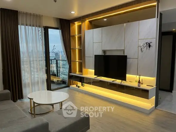 Modern living room with sleek TV unit and city view balcony.