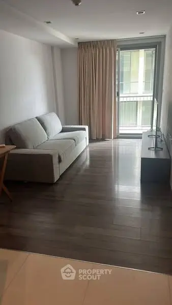 Spacious living room with modern sofa and large window for natural light.