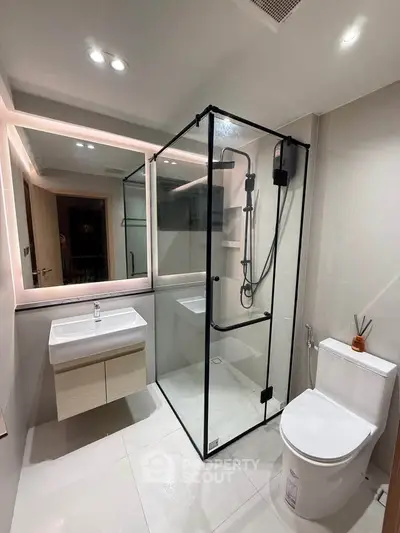 Modern bathroom with glass shower enclosure and sleek fixtures