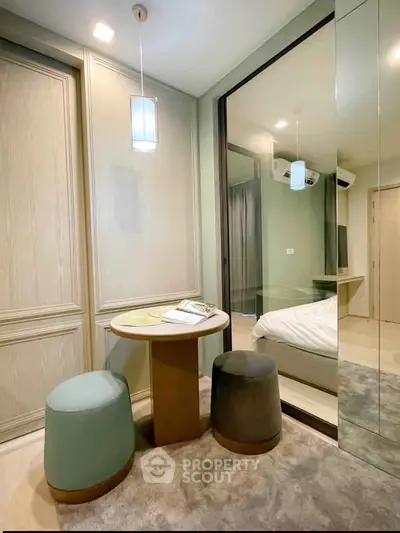 Cozy bedroom with modern decor and mirrored closet in a stylish apartment.