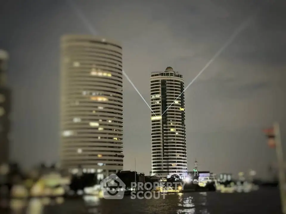 Stunning night view of illuminated modern high-rise buildings by the river.