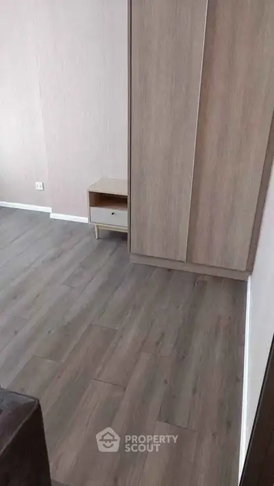 Modern bedroom with wooden flooring and minimalist furniture design.