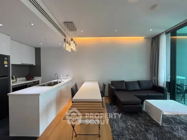Modern open-plan living room with sleek kitchen and stylish lighting