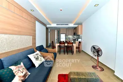 Modern living room with stylish decor and open kitchen layout, featuring cozy seating and elegant dining area.