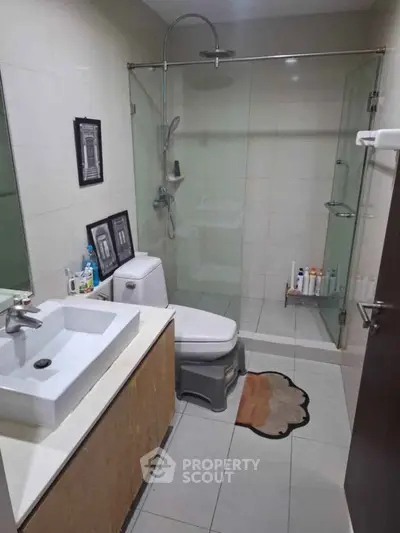 Modern bathroom with glass shower, sleek sink, and stylish decor in a contemporary home.