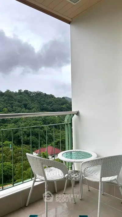 Charming balcony with scenic forest view, perfect for relaxation and outdoor dining.