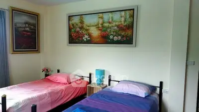 Charming bedroom with twin beds and vibrant artwork, perfect for cozy living.