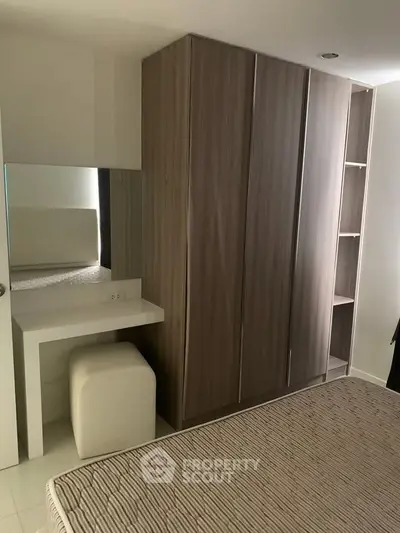 Modern bedroom with sleek wardrobe and cozy bed in stylish apartment.