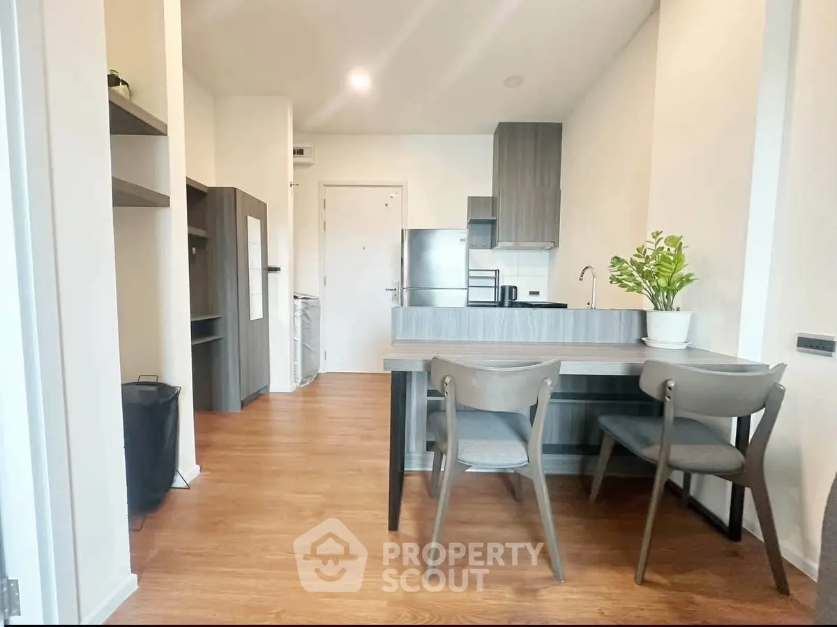 Modern kitchen with sleek cabinetry and dining area in stylish apartment