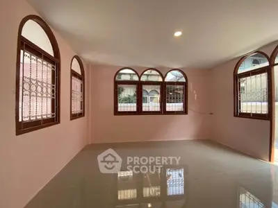 Spacious living room with arched windows and glossy tiled floor