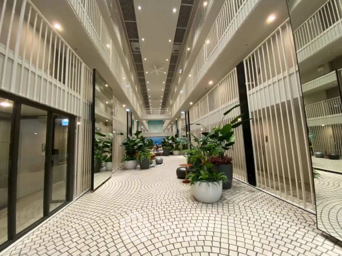 Stunning modern building entrance with elegant design and lush greenery