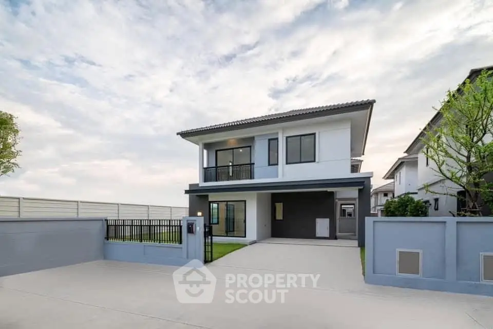 Modern two-story house with spacious driveway and sleek exterior design.