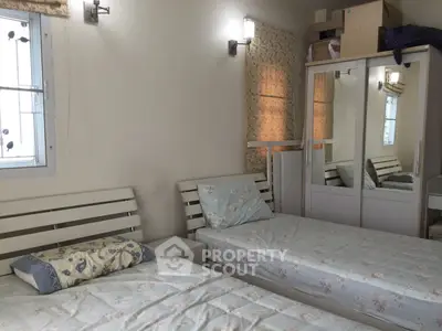 Cozy bedroom with twin beds and mirrored wardrobe, ideal for shared living.