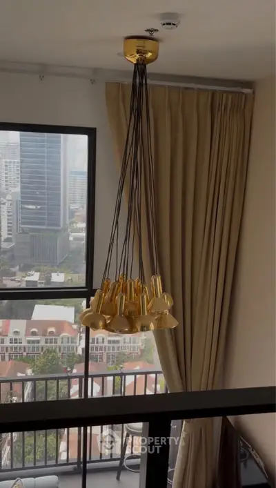 Modern apartment with stylish pendant lighting and city view from balcony.
