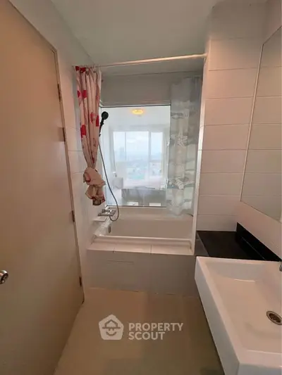 Modern bathroom with bathtub and city view window, featuring sleek design and natural light.