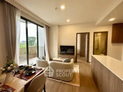 Modern living room with open layout and balcony view, featuring stylish furniture and elegant decor.