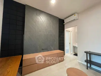 Modern living room with sleek black accent wall and wooden furniture