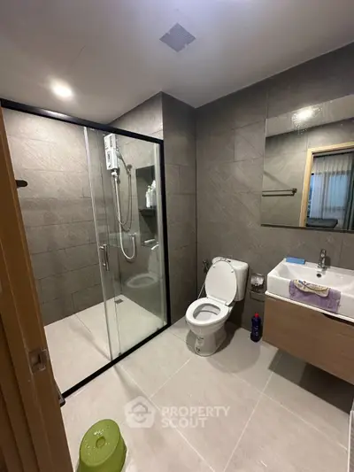 Modern bathroom with glass shower, sleek fixtures, and contemporary design.