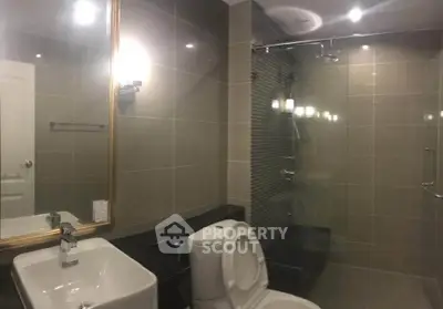 Modern bathroom with sleek fixtures and glass shower enclosure in a contemporary home.