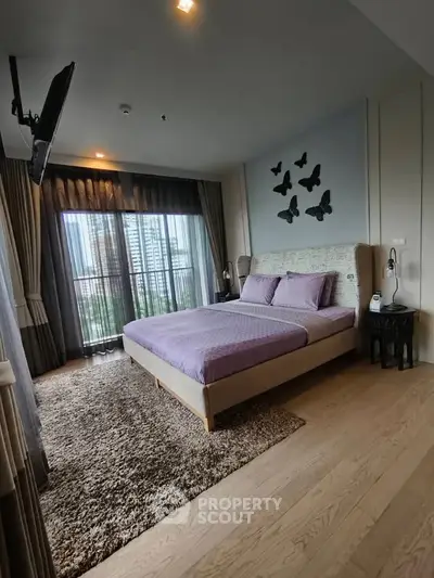 Luxurious bedroom with modern decor and city view, featuring elegant butterfly wall art and plush carpeting.