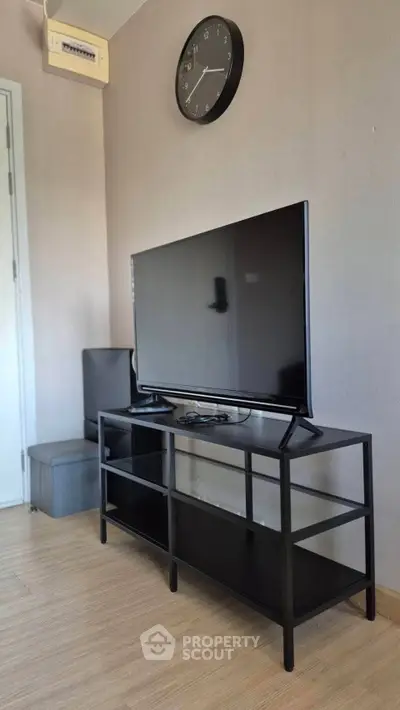 Modern living room with sleek TV stand and wall clock, showcasing minimalist design.