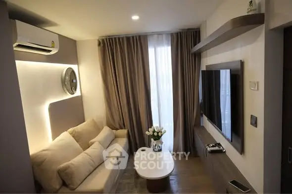 Modern living room with cozy sofa, wall-mounted TV, and elegant lighting