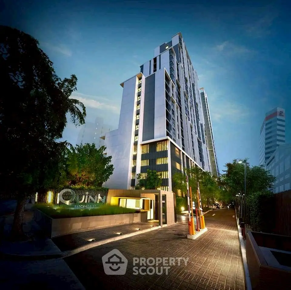 Stunning modern high-rise building with sleek architecture and illuminated entrance at dusk.