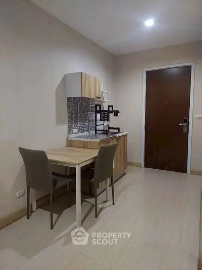 Cozy apartment kitchen with compact dining area and modern cabinetry.