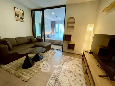Modern living room with cozy seating and stylish decor adjacent to a bedroom