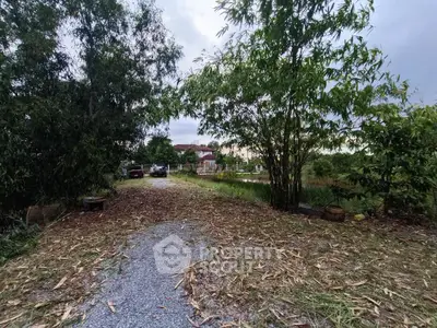 Charming garden pathway leading to a serene residential area with lush greenery.