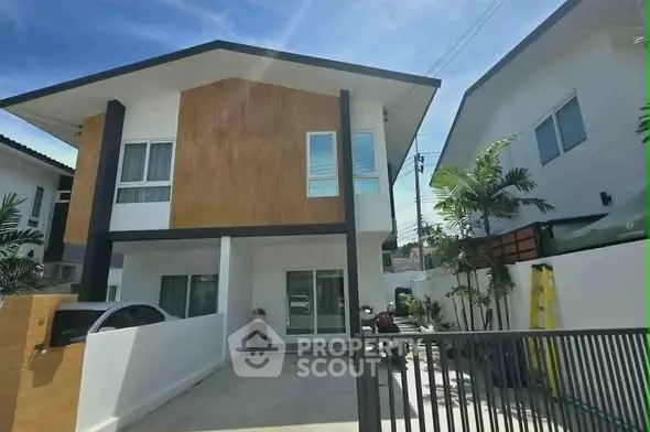 Modern two-story house with wooden facade and spacious driveway in a sunny neighborhood.