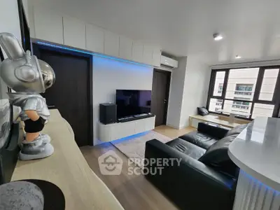 Modern living room with sleek design, featuring a black leather sofa, wall-mounted TV, and stylish decor.