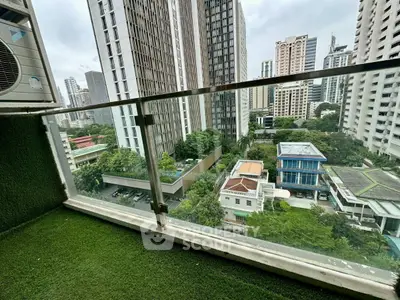 Stunning cityscape view from a high-rise balcony with lush greenery and modern buildings.