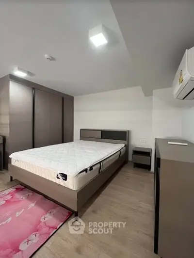 Modern bedroom with sleek furniture and air conditioning in a stylish apartment.