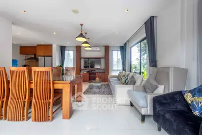 Spacious open-plan living and dining area with modern furnishings and large windows.