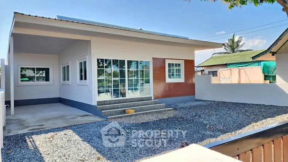 Modern single-story house with gravel yard and large windows