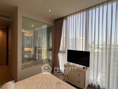Luxurious bedroom with large window and modern decor, featuring a TV and elegant curtains.