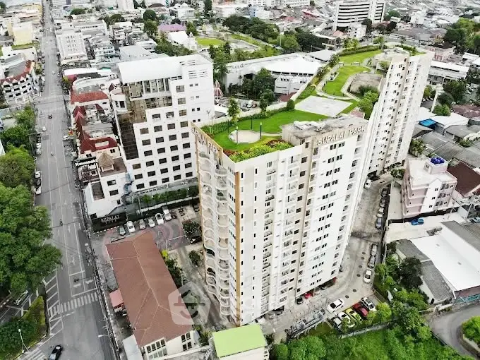 Stunning aerial view of modern high-rise building with lush rooftop garden in vibrant urban setting.