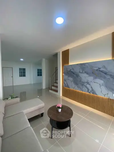 Modern living room with stylish marble accent wall and cozy seating area.