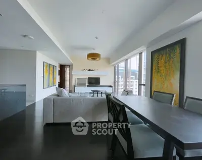 Spacious modern living room with elegant dining area and large windows offering city views.
