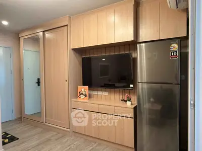 Modern living room with built-in wooden cabinets and stainless steel fridge