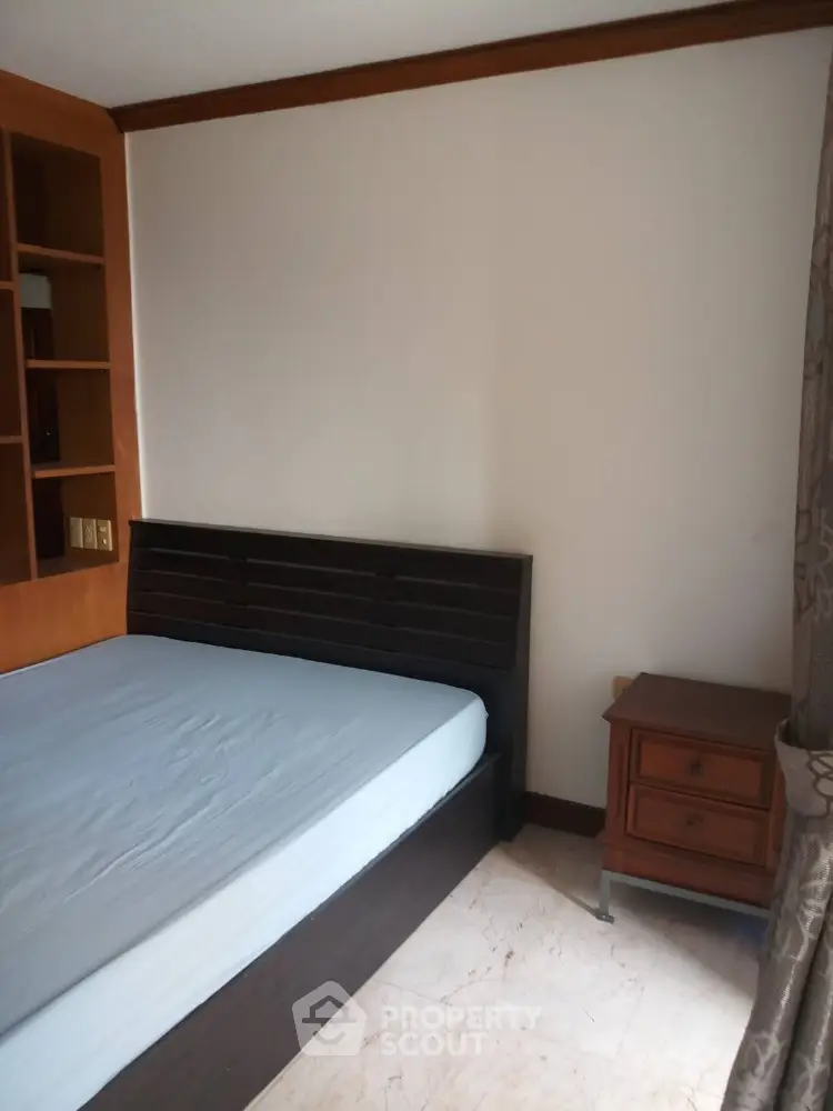 Cozy bedroom with wooden furniture and built-in shelving