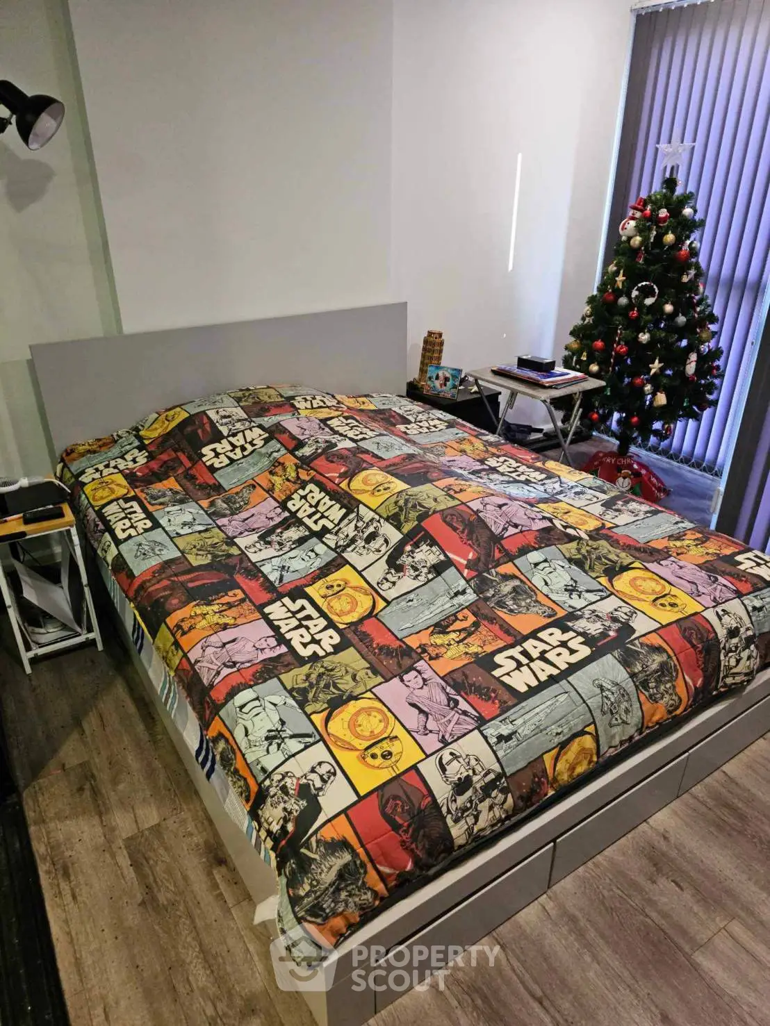 Cozy bedroom with Star Wars themed bedding and Christmas tree, perfect for sci-fi fans.