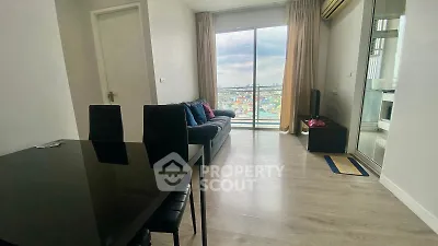 Modern living room with large window offering stunning city view, sleek furniture, and elegant decor.