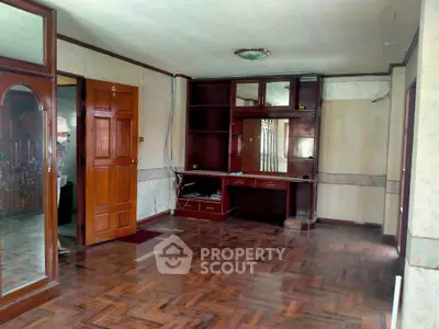 Spacious living room with wooden flooring and built-in shelving, ideal for modern living.