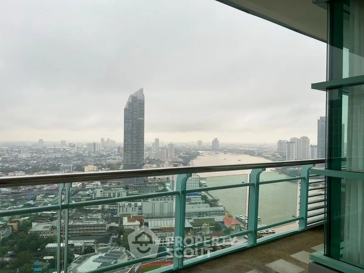Stunning cityscape view from a high-rise balcony overlooking a river and skyline.