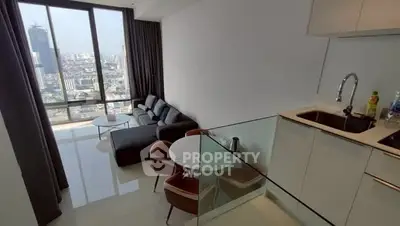 Modern open-layout living room with city view, featuring sleek kitchen and cozy seating area.