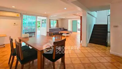 Spacious open-plan living and dining area with natural light and modern furnishings.