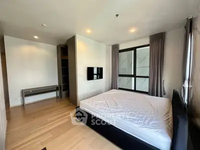 Spacious modern bedroom with large window and sleek furnishings