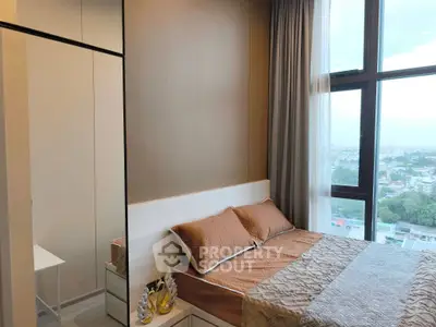 Modern bedroom with large window offering stunning city views and elegant decor.